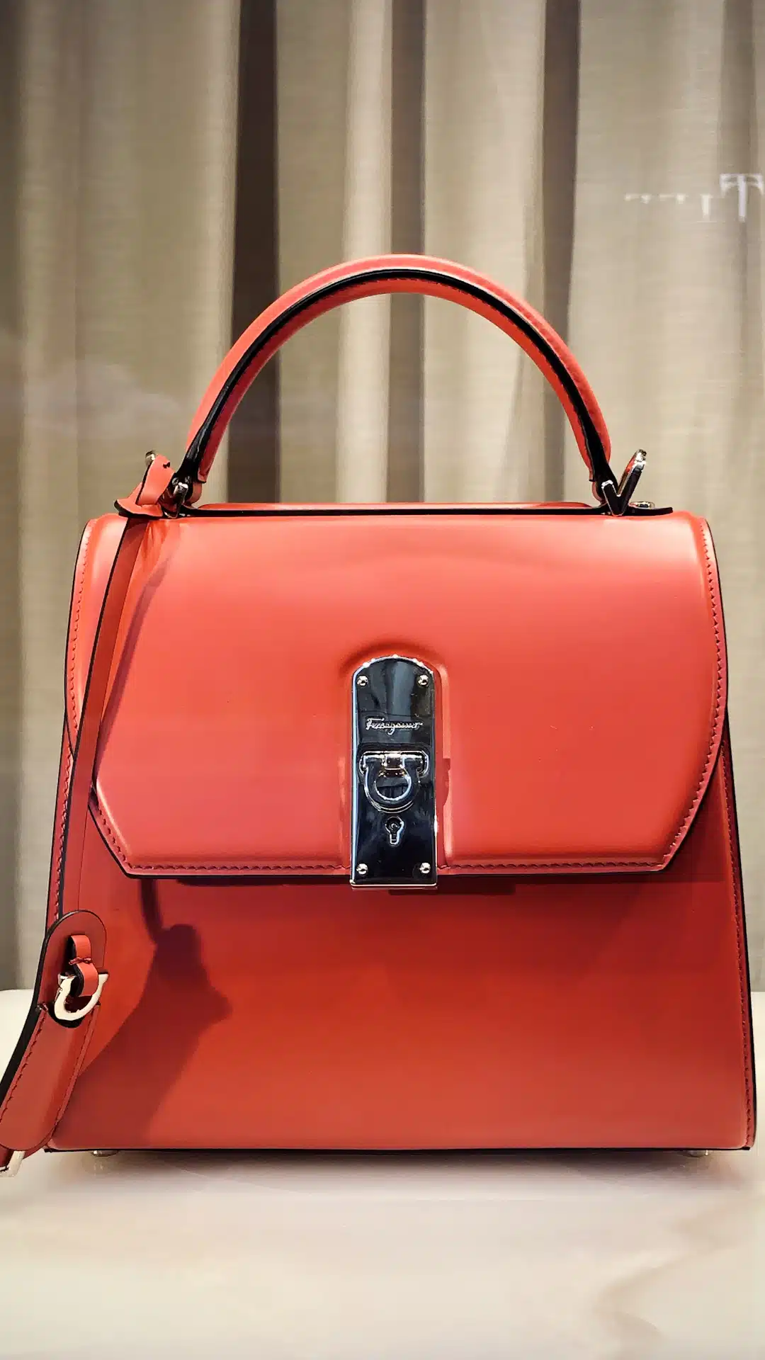 red leather handbag on white table