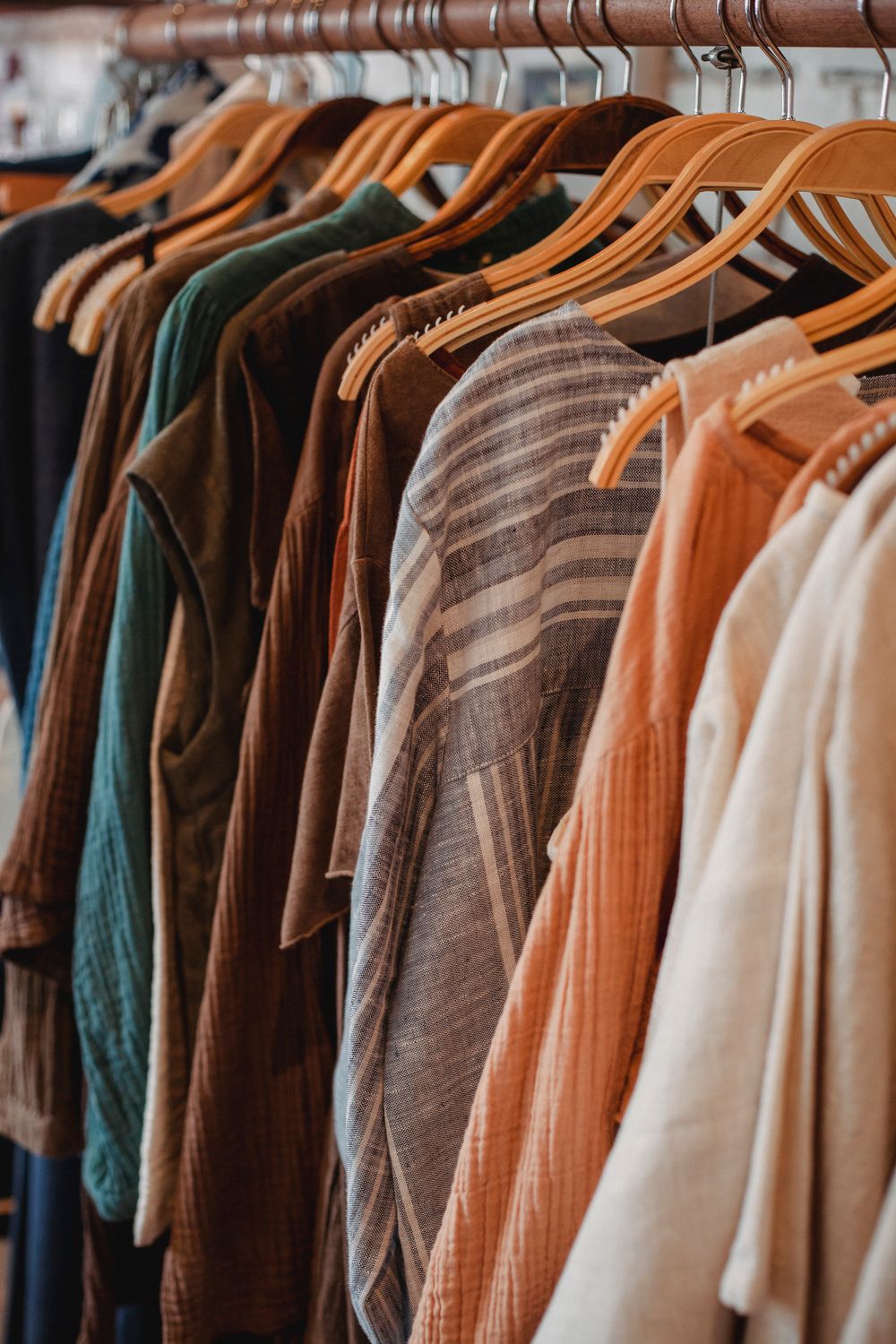 Collection of ornamental apparel on wooden racks hanging on metal beam of stand in shop